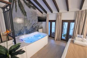 科尔多瓦Vitium Córdoba的带窗户的客房内设有带大浴缸的浴室