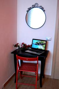 圣维托罗卡波B&B Vivere il Mare的一张黑色的桌子,上面有一台笔记本电脑和红色的椅子