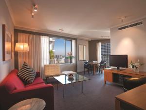 悉尼悉尼市政厅阿迪娜公寓式酒店的客厅配有红色沙发和电视