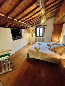 科尔托纳Pergaccio Deluxe House的一间卧室设有一张大床,铺有木地板