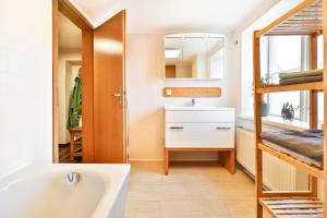 施特拉尔松德Ferienappartements Stralsund的带浴缸、水槽和镜子的浴室