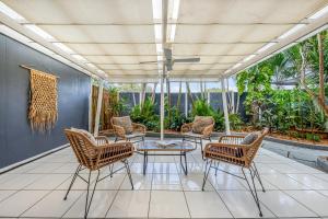 佩里吉安比奇巨浪佩里吉安海滩酒店的一个带桌椅和天花板的庭院