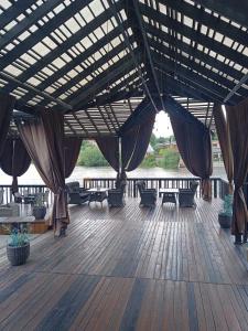 白采尔科维Rikabar Restaurant & nature的木制甲板上配有桌椅的凉亭