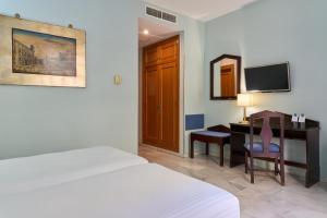 格拉纳达Porcel Navas的酒店客房配有一张床和一张带电脑的书桌