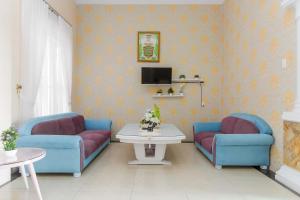 棉兰RedDoorz At Ralica Grand Palladium Medan的客厅配有2把蓝色椅子和桌子