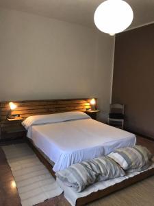 CassaroVilla delle Stelle的卧室配有白色的床和木制床头板