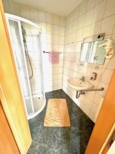 加姆利茨Steirer Haus的带淋浴、盥洗盆和浴缸的浴室