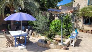 TormosCasa Alestelou的庭院配有桌子、遮阳伞和椅子