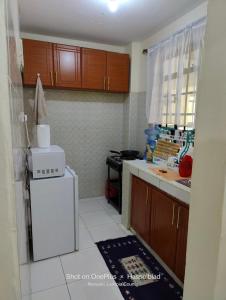 纳纽基Rovers Apartment的厨房配有白色冰箱和微波炉