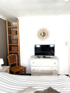 布兰肯贝赫Chez’ Elle的一间卧室配有一张床和一个带电视的梳妆台。