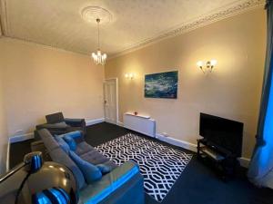 佩斯利Paisley Pad: Glasgow Gateway的带沙发和电视的客厅