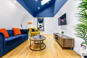 伦敦Spacious Contemporary 2 bed flat, Central London的客厅配有蓝色的沙发和桌子