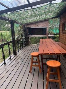 Playa VerdeCabaña Campestre Miramar的木甲板上的一张木桌和两张凳子