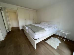 阿斯科纳Casa Segnale的卧室配有白色的床和凳子