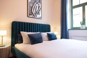 皮尔纳Hip & Minimalist - Stadt Apartments am Malerweg的一间卧室配有一张带绿色床头板的床