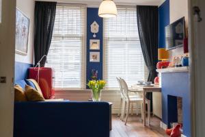 弗利辛恩Het Kasteeltje的客厅设有蓝色的墙壁和桌椅