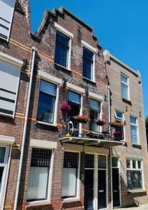 弗利辛恩Het Kasteeltje的一座砖砌建筑,阳台上装有窗户和鲜花