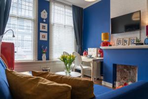 弗利辛恩Het Kasteeltje的客厅设有蓝色的墙壁和壁炉。