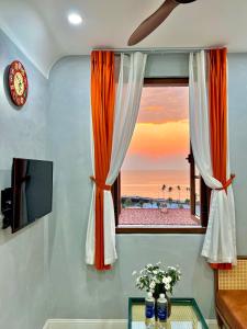 富国Rova Hotel Phú Quốc的享有海滩景致的橙色和白色窗户。