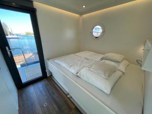 坎珀兰Houseboat Kamperland的一个小房间的一个床位,设有窗户