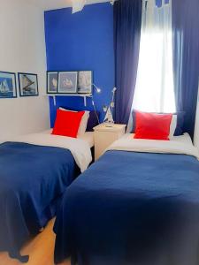 阿罗纳2 bedrooms appartement with shared pool furnished terrace and wifi at Costa del Silencio 1 km away from the beach的一间卧室配有两张带蓝色和红色枕头的床