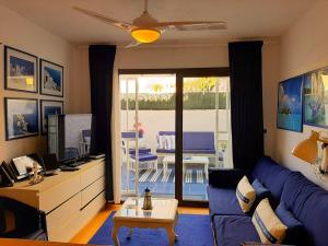 阿罗纳2 bedrooms appartement with shared pool furnished terrace and wifi at Costa del Silencio 1 km away from the beach的客厅配有蓝色的沙发和桌子