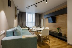 基辅Studio VIKTORY 5 В, 21 floor, Kyiv的客厅配有蓝色的沙发和桌子