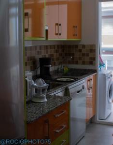 福斯Rapadoira Seaside Apartment的厨房配有橙色和绿色的橱柜和水槽