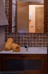 福斯Rapadoira Seaside Apartment的浴室水槽配有2条毛巾和镜子