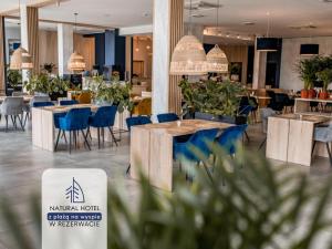 奥斯特罗达Natural Hotel w Rezerwacie z Plażą Na Wyspie的一间在房间内配有桌椅的餐厅