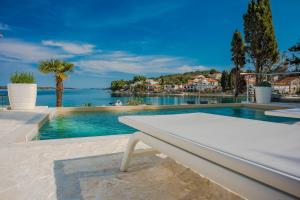 兹曼House with pool by the sea - Dugi otok, Žman的一个带白色长凳的泳池,享有水景