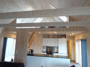 SandurCaptains Cottage的厨房设有木墙和木制天花板。