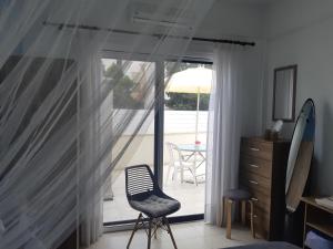 皮尔瓦利亚House Near The Beach (Militsa & Aggeliki)的一间带椅子和滑动玻璃门的房间