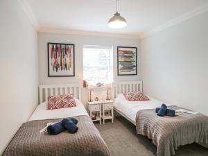 基督城9A Wick Lane的一间卧室设有两张床和窗户。