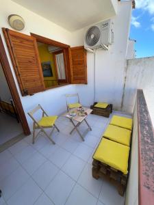 圣维托罗卡波Appartamento Girasole的阳台配有黄色椅子和桌椅。