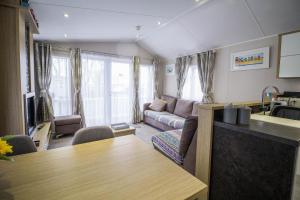 大雅茅斯Luxury Caravan With Decking Nearby Scratby Beach In Norfolk Ref 50001bm的客厅配有沙发和桌子