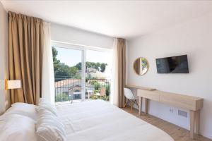 帕尔马诺瓦马丁内斯公寓酒店的一间卧室配有一张床、一张书桌和一个窗户。