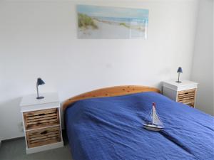 Groß KirrBirkenstr_ 14 Wohnung 1的一间卧室配有一张蓝色的床,上面有玩具帆船