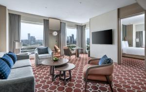 孟买孟买四季酒店的酒店客房设有沙发、椅子和电视。