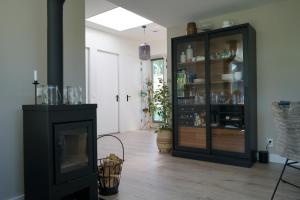 德科赫Texel Boogaloo的客厅设有壁炉和黑色橱柜。
