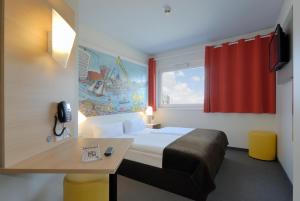 汉堡汉堡-哈尔堡住宿加早餐酒店的配有一张床、一张书桌和一扇窗户的酒店客房