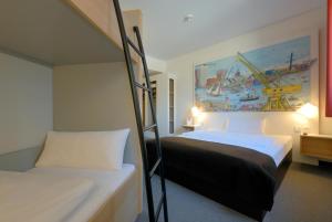 汉堡汉堡-哈尔堡住宿加早餐酒店的卧室配有两张双层床,墙上挂有绘画作品