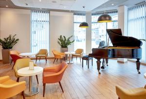 卡托维兹B&B Hotel Katowice Centrum的配有桌椅的房间的钢琴