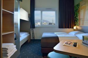 格拉茨B&B Hotel Graz City-Süd的酒店客房设有两张床和窗户。