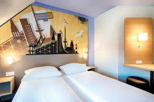 基尔B&B Hotel Kiel-Holstenbrücke的卧室配有一张白色床,墙上挂有绘画作品