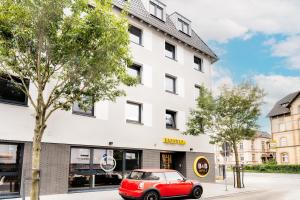 吉森B&B Hotel Gießen的停在大楼前的红色汽车