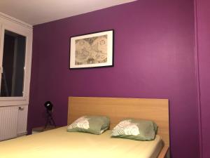 格勒诺布尔Chambre meublée prune boulevard Joseph Vallier的一间卧室设有紫色墙壁和一张带两个枕头的床
