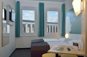 萨勒河畔哈雷哈勒（萨勒）B＆B酒店的客房设有床、桌子和窗户。