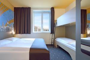 汉诺威B&B Hotel Hannover-City的一间卧室设有两张床和窗户。