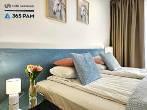 科沃布热格Resort Westin House - 365PAM的一间卧室配有一张带蓝色床头板的床和一张桌子